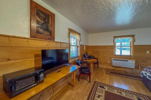 a living room with a flat screen tv and a table at Chinook Winds Lodge in Dubois