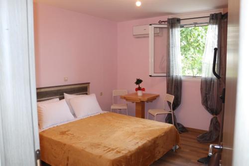 a bedroom with a bed and a table and a window at Katia 's Country House in Sikión