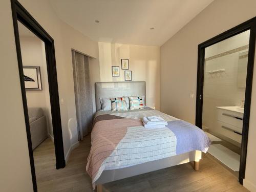 une petite chambre avec un lit et un miroir dans l'établissement Appartement cozy et hyper centre, à Menton
