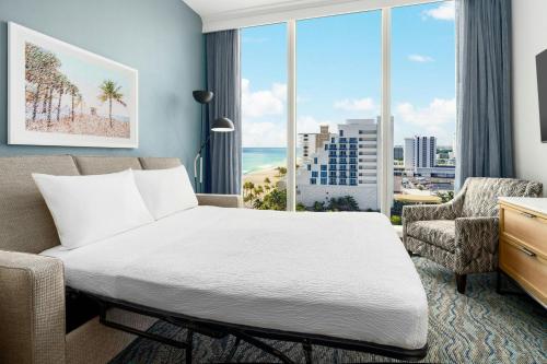 a bedroom with a bed and a large window at Courtyard by Marriott Oceanside Fort Lauderdale Beach in Fort Lauderdale