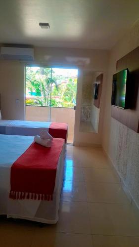 a hotel room with two beds and a window at Ayla Praia Hotel Centro Porto Segur in Porto Seguro