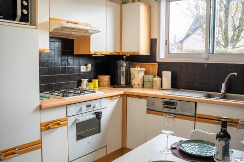 une cuisine avec une cuisinière blanche four supérieur à côté d'un évier dans l'établissement Maison, 3 ch, Proximité Gare,C Commercial,C ville, à Laval