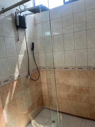 a shower with a glass door in a bathroom at 6 habitaciones, 10 camas, amplio y céntrico, 3 parqueos in Machala