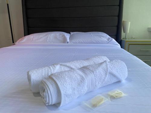 a bed with two rolls of towels on it at 6 habitaciones, 10 camas, amplio y céntrico, 3 parqueos in Machala