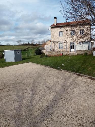 a dirt road in front of a stone house at Gîte La Béate des Arnauds in Tiranges
