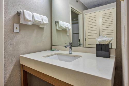 Un baño con un lavabo blanco y un espejo. en Courtyard Hampton, en Hampton
