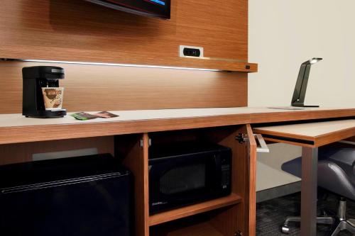 a desk with a microwave and a coffee maker on it at Courtyard by Marriott Cocoa Beach Cape Canaveral in Cocoa Beach
