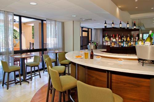 a bar in a restaurant with chairs and bottles of wine at Courtyard by Marriott Cocoa Beach Cape Canaveral in Cocoa Beach