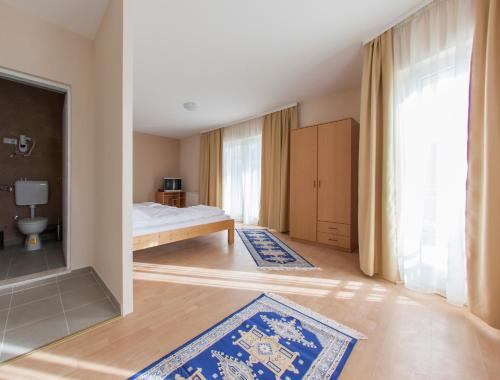 a bedroom with a bed and blue rugs at Hotel Hayat Hills in Sarajevo