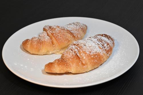 two pastries on a white plate on a table at B&B MareLuna in Angri