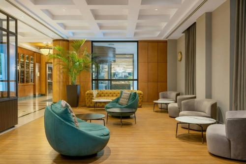 a lobby with couches and chairs in a building at Courtyard by Marriott Tbilisi in Tbilisi City