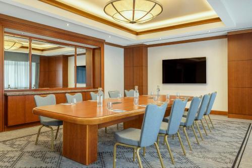 a conference room with a wooden table and chairs at Courtyard by Marriott Tbilisi in Tbilisi City
