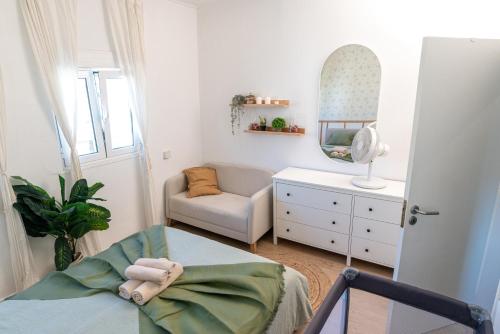 a room with a bed and a chair and a mirror at O seu refúgio no coração de Belém in Lisbon