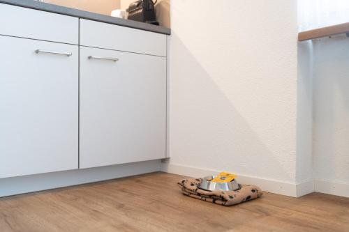 a toy dog is sitting on the floor in a kitchen at Apartment Alpenblick in Amden