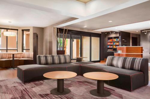 a living room with a couch and two tables at Courtyard by Marriott Springfield in Springfield