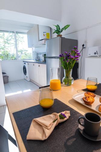 a kitchen with a table with two glasses of orange juice at O seu refúgio no coração de Belém in Lisbon