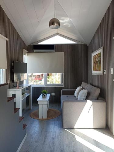 サン・ペドロにあるTiny Housesのソファとテーブルのあるリビングルーム