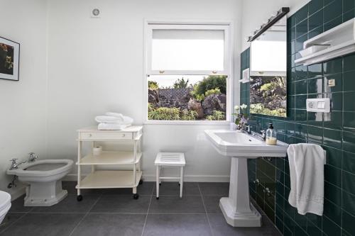 un bagno con lavandino, WC e finestra di Las Sabinas Villa - El Guincho, Garachico a Garachico