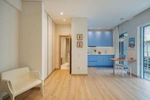 a kitchen with blue cabinets and a table and chairs at Athens Sea Front Apartment, Varkiza in Varkiza