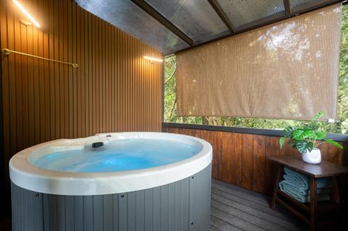 a hot tub in a bathroom with a window at Casa Violeta Home rentals in Monteverde Costa Rica