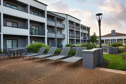 a row of chairs and a table in front of a building at Courtyard St. Louis Westport Plaza in Maryland Heights