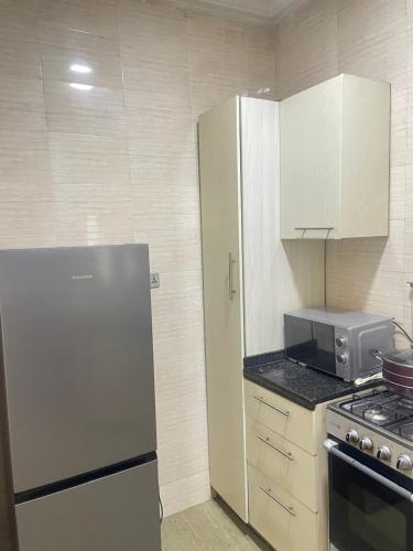 a kitchen with a refrigerator and a microwave at Kaygee two bedroom apartment in Lekki
