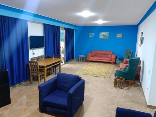 a living room with blue walls and a table and chairs at Blue nirvana beach house motel room 1 in Alexandria