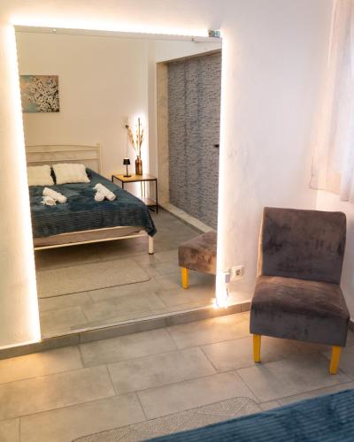a bedroom with a bed and a mirror and a chair at Bill and Dim in Xrisoupoli in Chrysoupolis