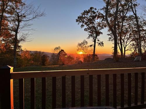 a bench with the sunset in the background at Wolf Ridge Lodge in Boone