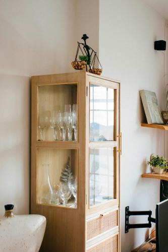 a wooden cabinet with glasses in it next to a window at Apartamento Atico-Spa in Santa Bárbara