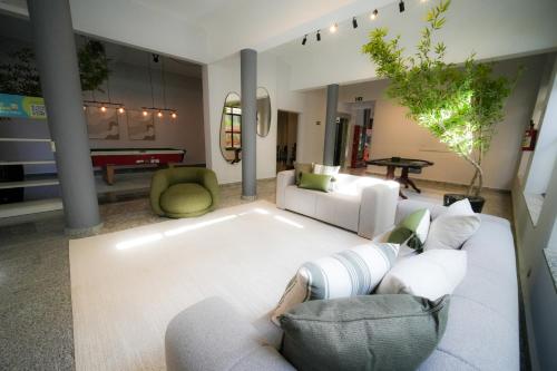 a living room with two white couches and a rug at Hotel Euro Suite Poços de Caldas By Nacional Inn in Poços de Caldas