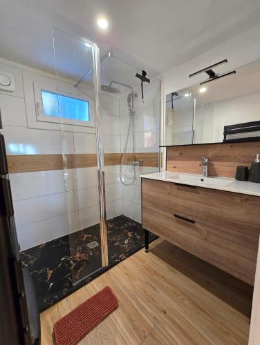 une salle de bain avec douche et lavabo dans l'établissement Oxygène - à 5min de la mer, grande terrasse vue mer - parking, vélo & terrain de tennis - By AURAconciergerie, aux Lecques