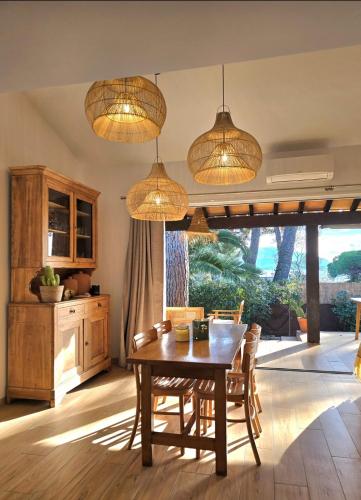 une salle à manger avec une table et quelques lumières dans l'établissement Oxygène - à 5min de la mer, grande terrasse vue mer - parking, vélo & terrain de tennis - By AURAconciergerie, aux Lecques