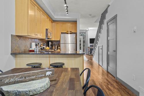a kitchen with wooden cabinets and a table with chairs at Mystic Chalet- Views, Pool, Hot Tub, Pets - managed by Little Sister Getaways in Canmore