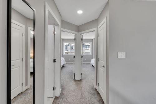 a hallway with white doors and a mirror at Luxury family vacation rental in Laurel Edmonton in Edmonton