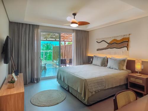 a bedroom with a large bed and a balcony at Hotel Velas do Engenho in Ilhabela