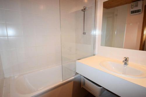 La salle de bains blanche est pourvue d'un lavabo et d'une baignoire. dans l'établissement Résidence Aime 2000 - Studio 3/4 pers - AIME 2000 - Partie Chamois - PLAGNE AIME 2000 MAE-8021, à La Plagne Tarentaise