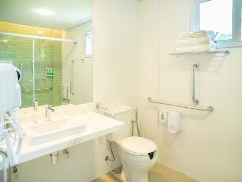 a white bathroom with a sink and a toilet at Hotel Velas do Engenho in Ilhabela