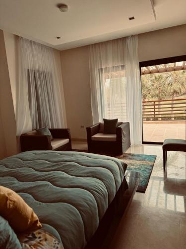 a bedroom with a bed and a large window at Mazagan private villa in El Jadida