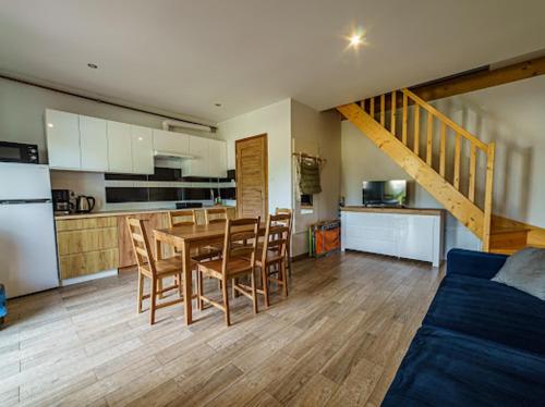 a kitchen and dining room with a table and chairs at Apartamenty Koło Brzegu in Gąski