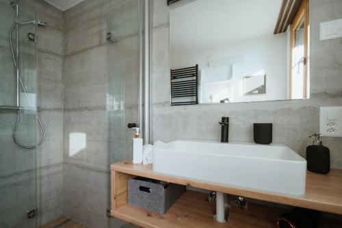 a bathroom with a white sink and a shower at Ferienhaus Daheim in Amden