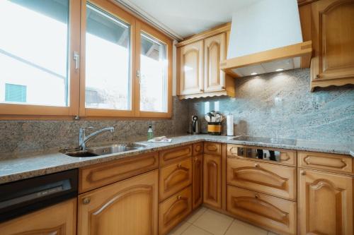 a kitchen with wooden cabinets and a sink and a window at Ferienhaus Daheim in Amden