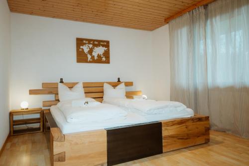 a bedroom with a large bed with white sheets at Apartment Bergzauber in Amden