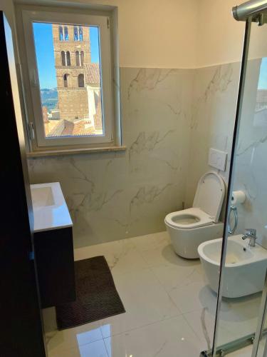 a bathroom with a toilet and a sink and a window at Il Campanile in Tivoli