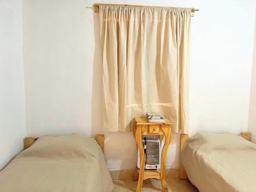 a bedroom with a window with a bed and a table at Cabaña La escondida I in Purmamarca