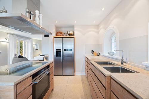 a large kitchen with a stainless steel refrigerator at Watthaus 1 in Tinnum
