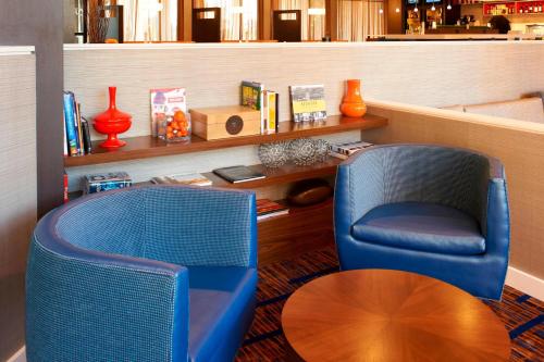 a room with two chairs and a table at Courtyard by Marriott Rockford in Rockford
