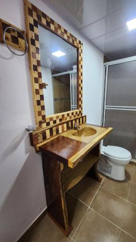a bathroom with a wooden sink and a mirror at Finca Nuevo Monarca in Pereira