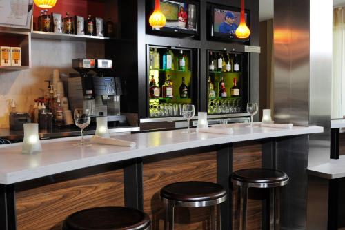 a bar with two stools and bottles of alcohol at Courtyard by Marriott Oklahoma City Airport in Oklahoma City
