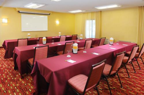 a conference room with tables and chairs and a screen at Courtyard by Marriott Oklahoma City Airport in Oklahoma City